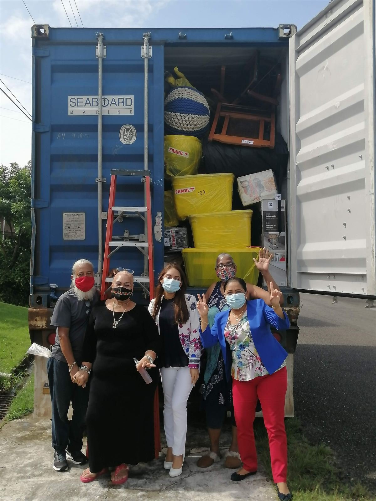 Clientes satisfechos junto a contenedor durante entrega puerta a puerta